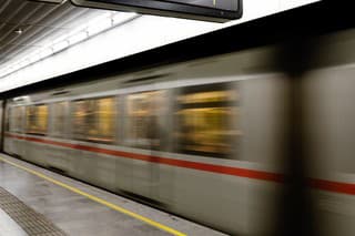 Vienna (Austria) subway underground station with a train running beside the platform