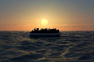 Refugees on a big rubber boat in the middle of the sea that require help. Sea with people in the water asking for help. Migrants crossing the sea