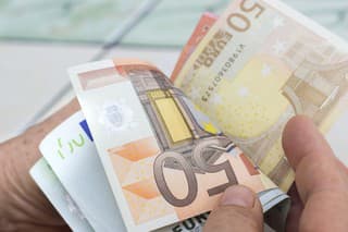 Close-up view of unrecognizable man counting money. Horizontal composition. Studio shot. Image developed from RAW format.