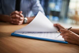 Cropped shot of a man and woman completing paperwork together at a desk