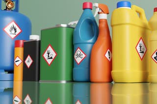 Plastic bottles and metallic tins having with different hazardous warning labels. Illustration of the concept of alert of chemical classification