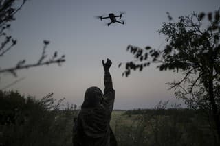 Na archívnej snímke z 19. augusta 2023 ukrajinský vojak sa naťahuje za dronom.