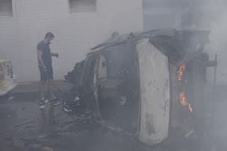Horiace autá na ulici po tom, ako ich zasiahli rakety vystrelené z pásma Gazy v izraelskom meste Aškelon