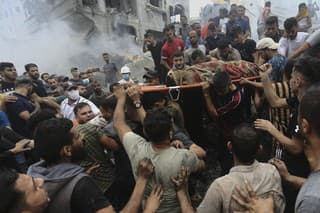  Palestínčania vynášajú mŕtve telo z ruín budovy po izraelskom leteckom útoku na utečenecký tábor Džabálija v pásme Gaza 9. októbra 2023.