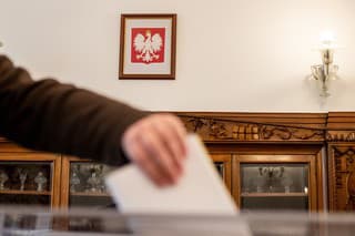 Poľskí občania odovzdávajú hlasovacie lístky. 