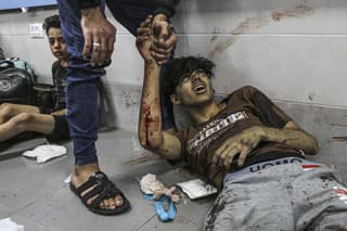 Na snímke zranení Palestínčania ležia na chodbe po raketovom útoku, zasiahol nemocnicu v pásme Gazy.
