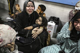 Zranení Palestínčania sedia na dlážke v nemocnici al-Shifa po ich príchode z nemocnice al-Ahli po explózii po tom, ako ju zasiahla raketa v Gaze 17. októbra 2023.
