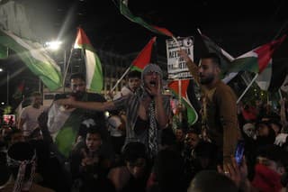 Demonštranti skandujú s palestínskymi zástavami počas protestu na vyjadrenie solidarity s Palestínčanmi v Gaze pred izraelským veľvyslanectvom v Aténach 18. októbra 2023. Tisíce ľudí demonštrovali v stredu v gréckom hlavnom meste Atény proti vojne medzi Izraelom a palestínskym militantným hnutím Hamas. 