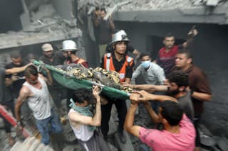 Palestínčania vynášajú telo obete, ktorú našli medzi troskami po raketovom útoku izraelskej armády v pásme Gazy v piatok 27. októbra 2023.