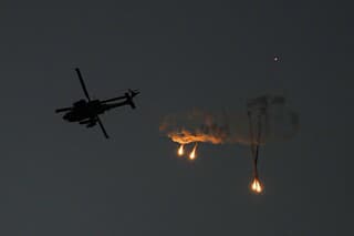 Izraelský vrtuľník Apache odpaľuje svetlice nad pásmom Gazy.