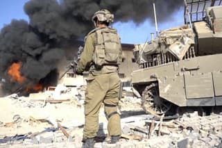 Na snímke izraelský vojak drží zbraň v meste Gaza.