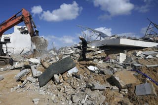 Palestínčania prehľadávajú v troskách zničeného domu telá rodiny Darwesh zabitých pri izraelskom bombardovaní pásma Gazy v utečeneckom tábore Nusseirat 20. novembra 2023.