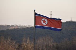 The North Korean flag flutters in the wind in rural North Korea.