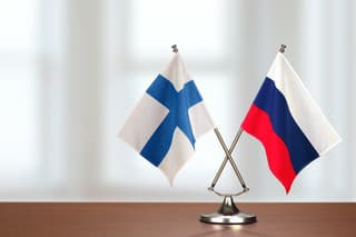 Two crossed national flags on wooden table
