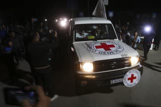 Na snímke vozidlo Červeného kríža s izraelskými prepustenými rukojemníkmi prechádza cez priechod v pásme Gazy do Egypta v Rafahu v stredu 29. novembra 2023.