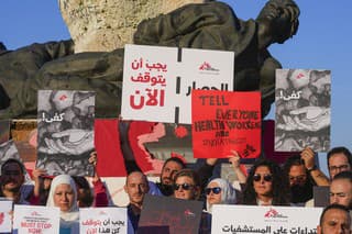 Členovia medzinárodnej humanitárnej skupiny Lekári bez hraníc držia transparenty počas protestu za ukončenie vojny v Gaze.