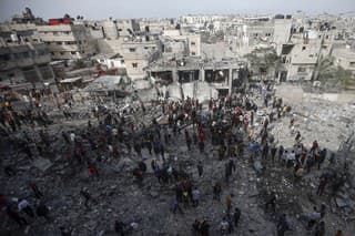 Palestínčania skúmajú škody na  zničenej budove po izraelských leteckých útokoch