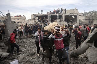 Palestínčania evakuujú zranenú ženu po izraelských leteckých útokoch na pásmo pásma Gazy v meste Chán Júnis, na juhu pásma Gazy 7. decembra 2023. 