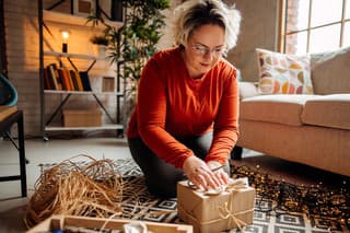 Woman wrapping Christmas present at home