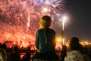 The opening night of L'International des Feux Loto-Québec, Montréal. A young girl is watching the show on her father's shoulders.