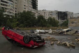 Vraky áut pri bytovkách, ktoré boli v predchádzajúcich mesiacoch značne poškodené ruskými útokmi