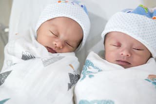 Newborn twins sleeping.Newborn Babies Twins Sleep in Bed. Lovely sleep of the newborns babies on the bed.