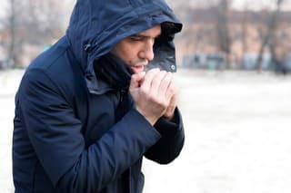 Man breathing on his hands to keep them warm