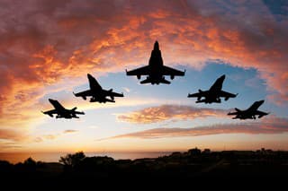 Five fighters flying at sunset