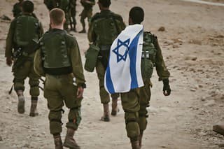 Back shot of several soldiers of israel army walking with an israel national flag. Military man walking with other soldiers. War tactical exercise.  Masada, Israel. 23 October 2018