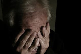 Desperate senior crying in a dark room. Perfectly usable for a wide range of topics like depression, loneliness or mental health in general