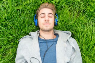 Young man with headphone listening to music in park