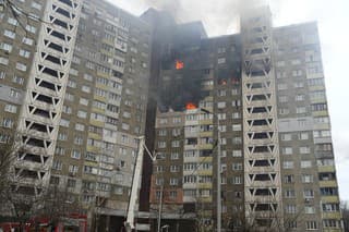 Hasiči pracujú na hasení požiaru v bytovom dome po ruskom útoku v Kyjeve.