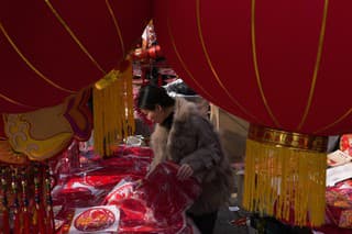 Ľudia kupujú novoročné dekorácie na trhu v Pekingu 9. februára 2024 pred blížiacimi sa oslavami čínskeho lunárneho Nového roka.