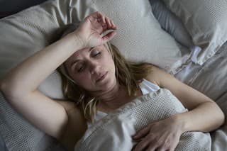 Menopausal Mature Woman Suffering With Insomnia In Bed At Home