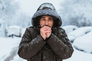 Portrait of the caucasian man in a hat on the street in winter.