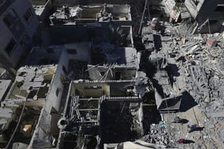  Palestínčania prehľadávajú trosky zničených obytných budov po izraelskom leteckom útoku na pásmo Gazy.