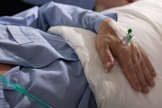 Close-up of terminally ill man's hand with drip