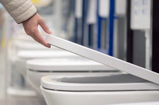 Buyer choosing a new toilet sanitary ware on construction store.