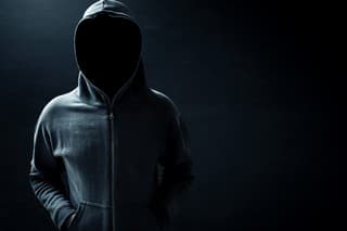 Hacker standing alone in dark room
