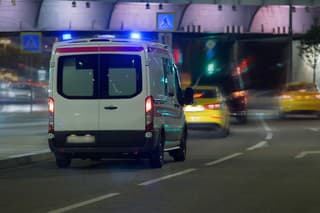 Ambulance car moves at night along a city street. Blurry motion