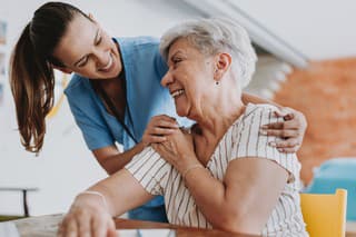 Home care healthcare professional hugging senior patient