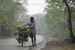 Na snímke muž tlačí bicykel s nákladom zeleniny na predaj na predmestí Gauhátí v Indii v stredu 20. marca 2024.