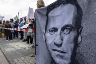 Na snímke ľudia držia transparent s podobizňou Alexeja Navaľného