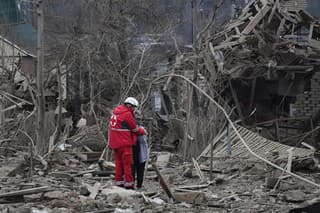 Záchranár objíma ženu po ruskom leteckom útoku na priemyselné mesto Záporožie na juhovýchode Ukrajiny v piatok 22. marca 2024.