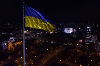 Ukrainian flag in the wind. Blue Yellow flag Against the city at night