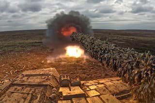 Na snímke z videa zverejnenej ruským ministerstvom obrany ruský tank vystreľuje na Ukrajinu z neznámeho miesta.