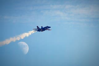 Miramar, California, USA - September 23, 2023: Blue Angel Number 3, LCDR Amanda Lee, passes in front of the moon at America's Airshow 2023.