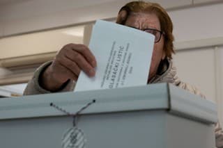 Žena v Chorvátsku vkladá do urny hlasovací lístok. 
