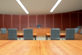 Empty Courtroom Interior With Wooden Desk And Blurred Background