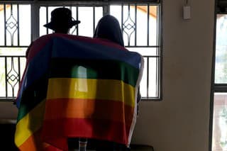 Na archívnej snímke z 25. marca 2023 homosexuálny pár pózuje s dúhovou vlajkou v Ugande.